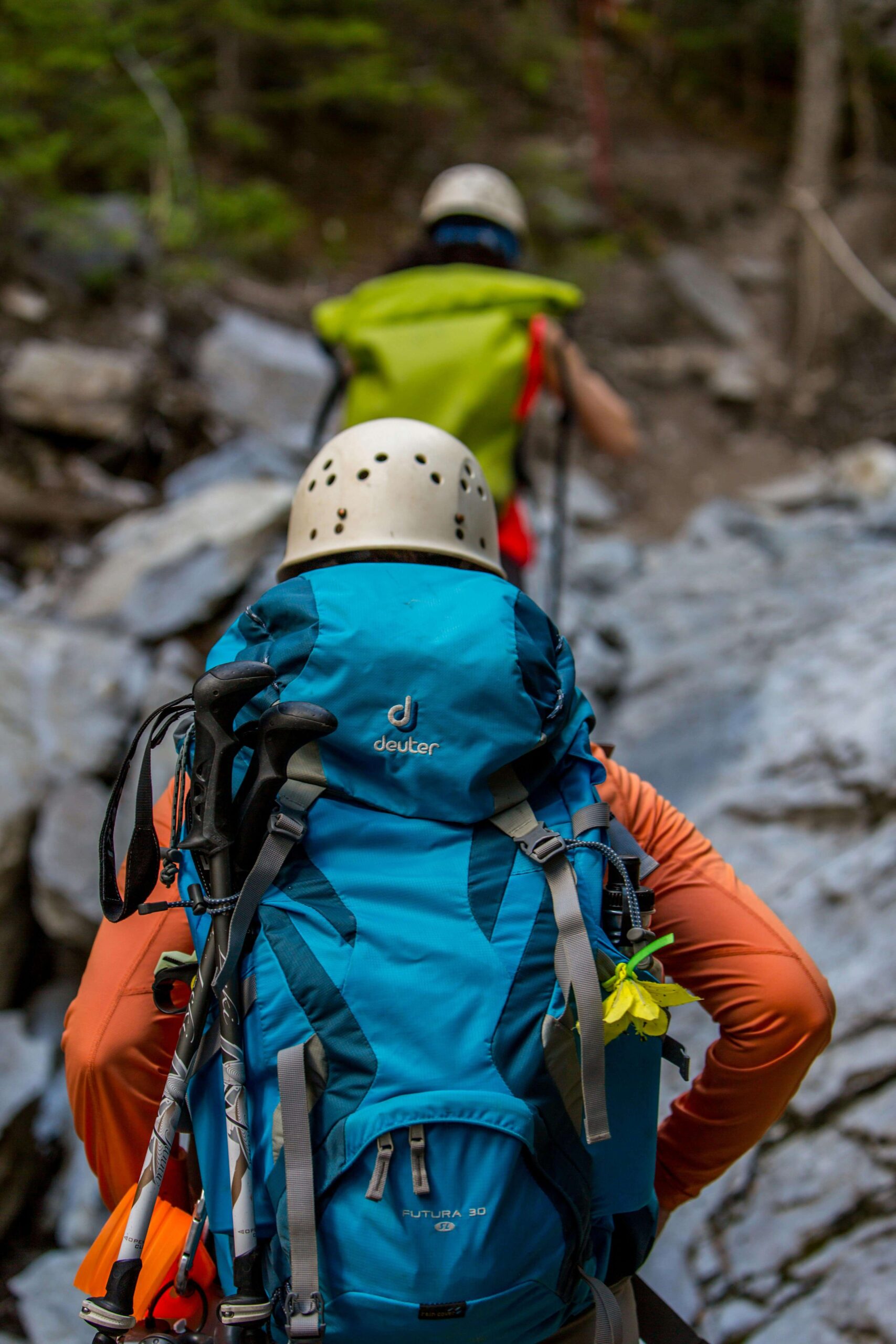 a picture of a trekker wearing orange suit with a blue back pack used by a tour planner website Adventure Tunes